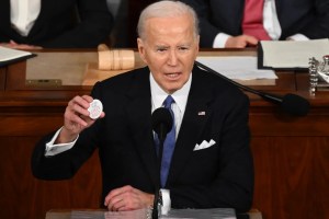 President Joe Biden holds a "Say her name Laken Riley" button while delivering the State of the Union address in the House Chamber of the US Capitol in Washington, DC, on March 7. Saul Loeb/AFP/Getty Images
