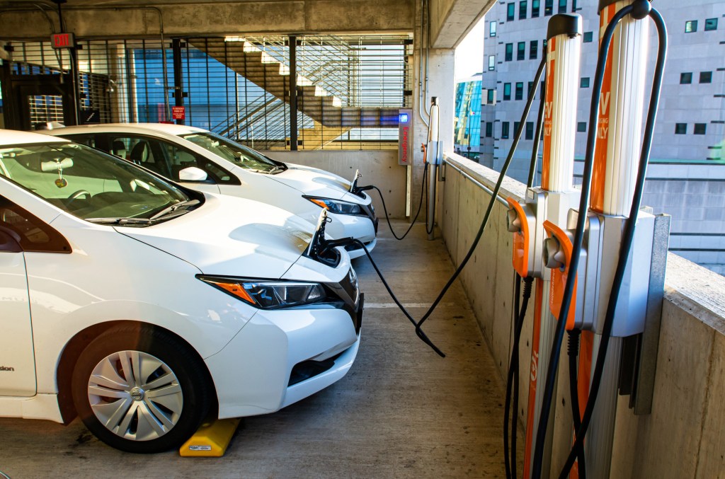 Two white Nissan Leaf electric cars charge in a parking garage in Columbus, Ohio.