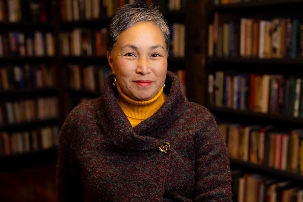 A portrait of Annamaria Leon with bookshelves in the background.